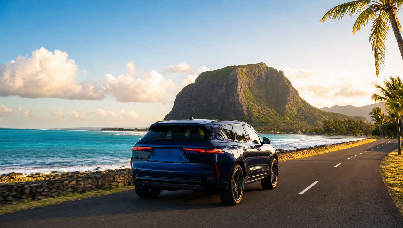 A car on a coastal road in Mauritius with a mountain and turquoise lagoon behind